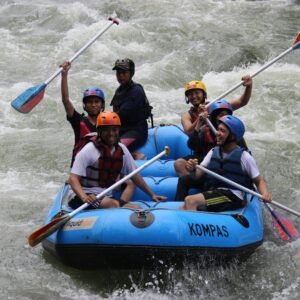 Group enjoying thrilling white water rafting on a river in Yogyakarta, Indonesia.
